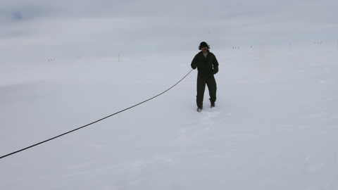 A crew member of a ski-equipped C-130 from the New York Air National Guard stands near the plane on July 11, 2013 at the Summit Station, Greenland. (Joe Raedle/Getty Images)