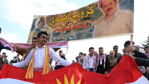 Iraqi Kurds hold the Kurdish flag and a poster of Iraqi Kurdistan's regional president Masoud Barzani (R) in Akra, Iraq's, March 20, 2014. (SAFIN HAMED/AFP/Getty Images)