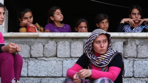 Iraqi Yazidi women who fled the violence in the northern Iraqi town of Sinjar sit in the Kurdish city of Dohuk on August 5, 2014. (SAFIN HAMED/AFP/Getty Images)