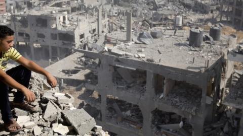 A Palestinian man looks out over destruction in part of Gaza City's al-Tufah neighbourhood as the fragile ceasefire in the Gaza Strip entered a second day on August 6, 2014. (MAHMUD HAMS/AFP/Getty Images)