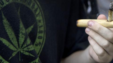 A man smokes a joint during a march for the legalization of marijuana towards the Legislative Palace in Montevideo, on December 10, 2013. (PABLO PORCIUNCULA/AFP/Getty Images)