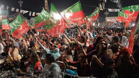 Supporters of Pakistani cricketer-turned politician Imran Khan wave party flags during an anti-government protest in front of the Parliament in Islamabad on September 13, 2014. (AAMIR QURESHI/AFP/Getty Images)