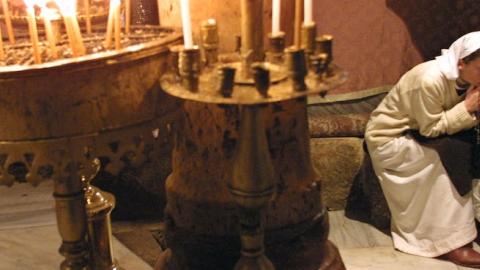 Sister Ann-Elisabeth prays in the Grotto of the Church of the Nativity in Bethlehem, December 20, 2001. (David Silverman/Getty Images)