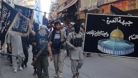 Islamic fighters from the Al-Nusra Front carry a banner of Jerusalem's Dome of the Rock mosque with the Arabic slogan: 'We fight in Syria... and our eyes are on Jerusalem' on July 28, 2014. (RAMI AL-SAYED/AFP/Getty Images)