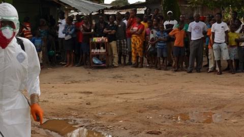 A Liberian Red Cross health worker disinfects a courtyard on September 10, 2014 in a district of Monrovia. (ZOOM DOSSO/AFP/Getty Images)