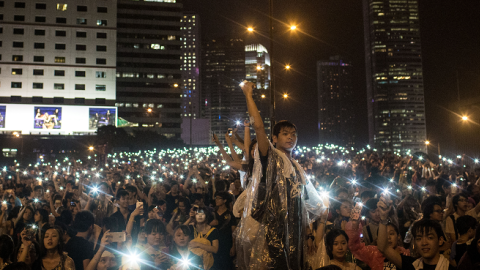 Protesters sing songs and wave their cell phones in the air after a massive thunderstorm passed over outside the Hong Kong Government Complex on September 30, 2014. (Chris McGrath/Getty Images)
