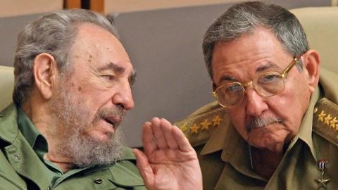 Cuban President Fidel Castro (L) and his brother Raul, Minister of the Revoutionary Armed Forces,  in Havana, during a meeting of the Cuban Parliament, December 23, 2003. (ADALBERTO ROQUE/AFP/Getty Images)