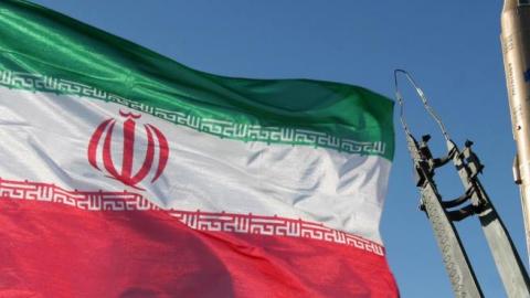 An Iranian flag flutters next to a ground-to-ground Sajil missile before being launched at an undisclosed location in Iran on November 12, 2008. (-/AFP/Getty Images)