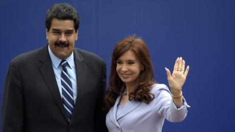 Argentinian President Cristina Kirchner (R) waves next to Venezuelan President Nicolas Maduro during the 47th Mercosur Summit, in Parana, Entre Rios, Argentina on December 17, 2014. (JUAN MABROMATA/AFP/Getty Images)