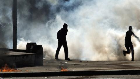 Egyptian students who support the Muslim Brotherhood run from tear gas fired by riot police during clashes following a demonstration outside Cairo University on March 26, 2014. (KHALED DESOUKI/AFP/Getty Images)