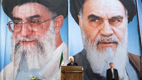 Iranian President Hassan Rouhani under portraits of Iran's supreme leader, Ayatollah Ali Khamenei (C-L) and Iran's founder of the Islamic Republic, Ayatollah Ruhollah Khomeini (C-R), in a suburb of Tehran on June 3, 2014. (ATTA KENARE/AFP/Getty Images)
