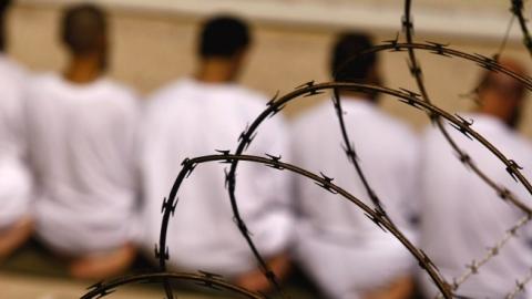 Detainees kneel during early morning Islamic prayer on October 28, 2009 in Guantanamo Bay, Cuba. (John Moore/Getty Images)