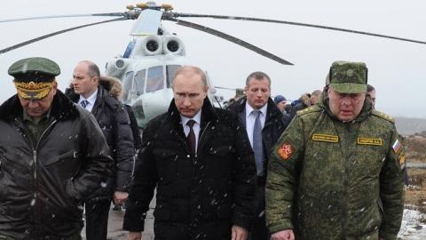 Russia's President Vladimir Putin (front C) and Defence Minister Sergei Shoigu (front L) walk to watch military exercises upon his arrival at the Kirillovsky firing ground in the Leningrad region, on March 3, 2014. (MIKHAIL KLIMENTYEV/AFP/Getty Images)