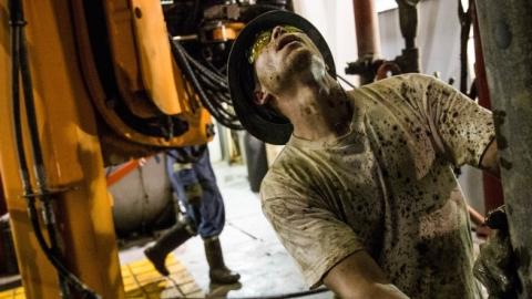 Russell Girsh, a floor hand for Raven Drilling, helps line up a pipe while drilling for oil in the Bakken shale formation on July 23, 2013 outside Watford City, North Dakota. (Andrew Burton/Getty Images)