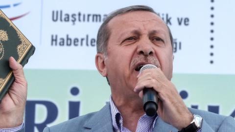 Turkey's President Recep Tayyip Erdogan holds a Koran at the opening ceremony of the Selehaddin Eyyubi airport on May 26, 2015, in eastern city of Hakkari. (STR/AFP/Getty Images)