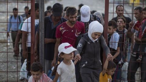 After having their papers processed, migrant families walk out of a transit area toward a train station, Sept. 3, Gevgelija, Macedonia. (Dan Kitwood/Getty Images)