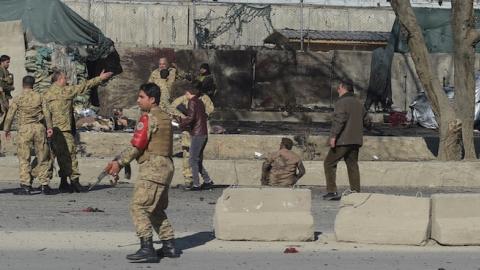 Afghan security personnels gather as victims are treated at the site of a suicide car bomb next to a police base in Kabul on February 1, 2016. (SHAH MARAI/AFP/Getty Images)