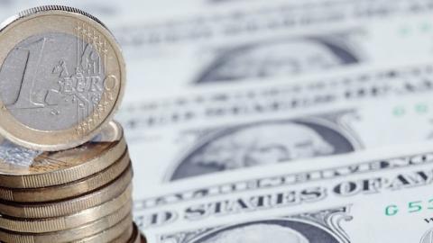 Euro coins sit on a display of one Dollar notes, on November 26, 2010 in London, England. (Dan Kitwood/Getty Images)