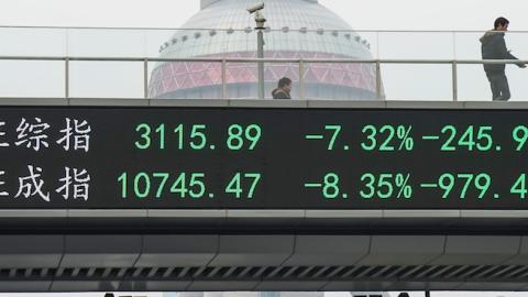 A man passes by electric screen showing Chinese shares decrease sharply to a halt point on January 7, 2016 in Shanghai, China. (ChinaFotoPress/Getty Images)