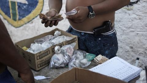 A drug dealer and member of the ADA Gang counts the money from a drug transaction, February 9, 2014. (Sebastiano Tomada/Reportage by Getty Images)