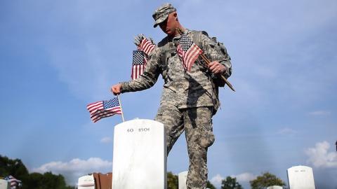 Members of the 3rd U.S. Infantry Regiment place American flags at the graves of U.S. soldiers buried in Section 60 at Arlington National Cemetery in preparation for Memorial Day May 24, 2012 in Arlington, Virginia. (Win McNamee/Getty Images)