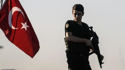 A Turkish anti riot police officer stands guard on a tank after a military position on the Bosphorus bridge was taken over in Istanbul on July 16, 2016. (OZAN KOSE/AFP/Getty Images)