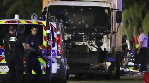 Police officers and rescue workers stand near a van that ploughed into a crowd leaving a fireworks display in the French Riviera town of Nice on July 14, 2016. (VALERY HACHE/AFP/Getty Images)