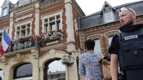 A French police officer stands guard by Saint-Etienne-du-Rouvray's city hall following a hostage-taking at a church in Saint-Etienne-du-Rouvray, northern France, on July 26, 2016 that left the priest dead. (CHARLY TRIBALLEAU/AFP/Getty Images)