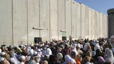 Palestinians gather at a check point on the outskirts of Bethlehem (Photo by MUSA AL-SHAER/AFP/Getty Images)