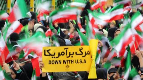 Iranian schoolgirls wave their national flag and hold an anti-US slogan during celebrations in Tehran's Azadi Square (Freedom Square) to mark the 37th anniversary of the Islamic revolution on February 11, 2016. (ATTA KENARE/AFP/Getty Images)