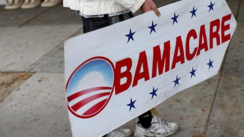 Pedro Rojas holds a sign directing people to an insurance company where they can sign up for the Affordable Care Act before the February 15th deadline on February 5, 2015 in Miami, Florida. (Joe Raedle/Getty Images)