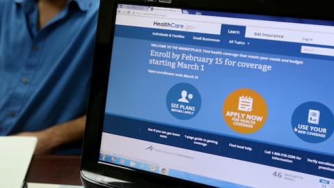 Hisham Uadadeh enrolls in a health insurance plan under the Affordable Care Act with the help of A. Michael Khoury at Leading Insurance Agency on February 13, 2014 in Miami, Florida. (Joe Raedle/Getty Images)