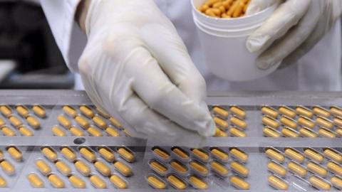 An employee fills blister packs with capsules at the end of the production chain at the Juva Sante Laboratoires plant, on March 13, 2013 in Forbach, France. (JEAN-CHRISTOPHE VERHAEGEN/AFP/Getty Images)