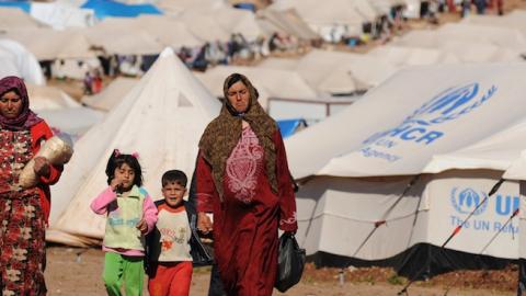 Syrian internally displaced people walk in the Atme camp, along the Turkish border in the northwestern Syrian province of Idlib, on March 19, 2013. (BULENT KILIC/AFP/Getty Images)