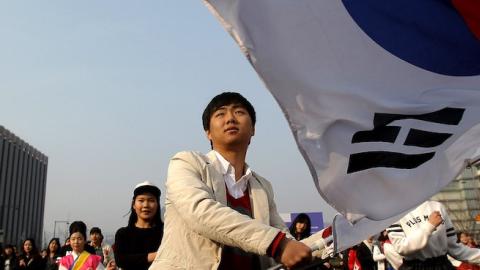A South Korean student waves national flags during a rally on February 22, 2014 in Seoul, South Korea. (Chung Sung-Jun/Getty Images)
