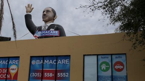 A sign waves from the top of insurance co. roof advertising for the Affordable Care Act, also known as Obamacare, as the company tries to sign people up before the February 15th deadline on February 5, 2015 in Miami, Florida. Numbers released by the gover