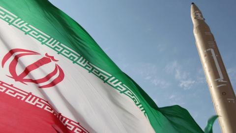 A flag flying at an undisclosed location in Iran next to a surface-to-surface Qiam-1 (Rising) missile, August 20, 2010. (VAHID REZA ALAEI/AFP/Getty Images)