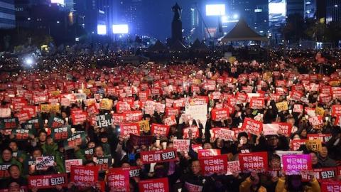 Protesters hold candles and banners calling for the resignation of South Korea's President Park Geun-Hye during an anti-government rally in central Seoul on November 19, 2016. (JUNG YEON-JE/AFP/Getty Images)