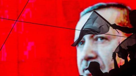 People wave Turkish flags in front of an electronic billboard displaying the face of President Recep Tayyip Erdogan at a rally on the streets of Kizilay Square on July 17, 2016 in Ankara, Turkey. (Chris McGrath/Getty Images)