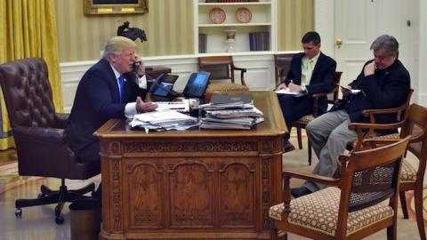 US President Donald Trump speaks on the phone with Australia's Prime Minister Malcolm Turnbull, with Chief Strategist Steve Bannon (R) and National Security Advisor Michael Flynn, from the Oval Office on January 28, 2017. (MANDEL NGAN/AFP/Getty Images)