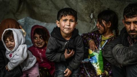 A Syrian refugee family from Aleppo, stay under a shelter during a rainy day on March 8, 2014, at Uskudar in Istanbul. (BULENT KILIC/AFP/Getty Images)