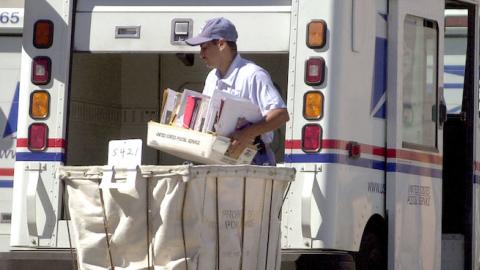 A United States mail carrier loads his truck August 23, 2001 in Modesto, California. (Justin Sullivan/Getty Images)