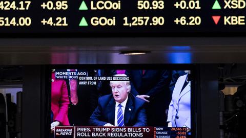 A television monitor shows President Donald Trump on the floor of the New York Stock Exchange, March 27, 2017 (Drew Angerer/Getty Images)