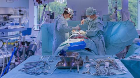 Surgeons performing open heart surgery in modern operating room (Thierry Dosogne)