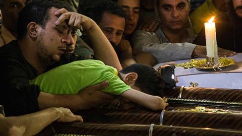 Child cries besides the coffins of his parents, who were killed in the Minya Bus Attack on May 26, 2017 (Ibrahim Ezzat/NurPhoto via Getty Images)