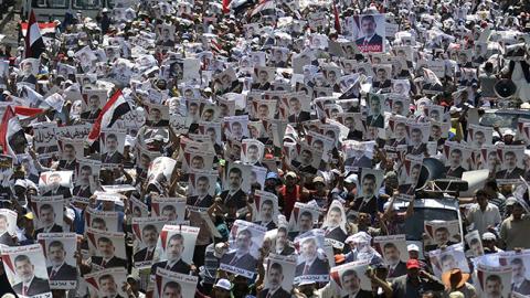 Muslim Brotherhood supporters carry portraits of ousted president Mohamed Morsi outisde Rabaa al-Adawiya mosque in Cairo, July 26, 2013 (MOHAMED EL-SHAHED/AFP/Getty Images)