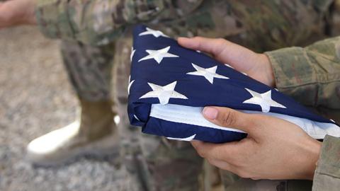 A US soldier holds the national flag ahead of a handover ceremony at Leatherneck Camp in Helmand province, Afghanistan, April 29, 2017 (WAKIL KOHSAR/AFP/Getty Images)