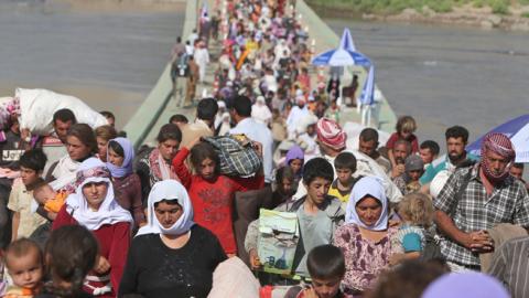 Displaced Yazidis cross the Syrian-Iraqi border, August 13, 2014 (AHMAD AL-RUBAYE/AFP/Getty Images)