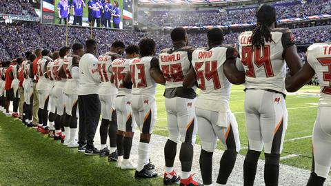 Tampa Bay Buccaneers players link arms on the sidelines during the national anthem before the game against the Minnesota Vikings, September 24, 2017 (Hannah Foslien/Getty Images)