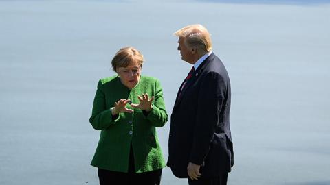 Germany's Chancellor Angela Merkel and U.S. President Donald Trump speak together on the first day of the G7 Summit, on June 8, 2018 in La Malbaie, Canada. (Leon Neal/Getty Images)